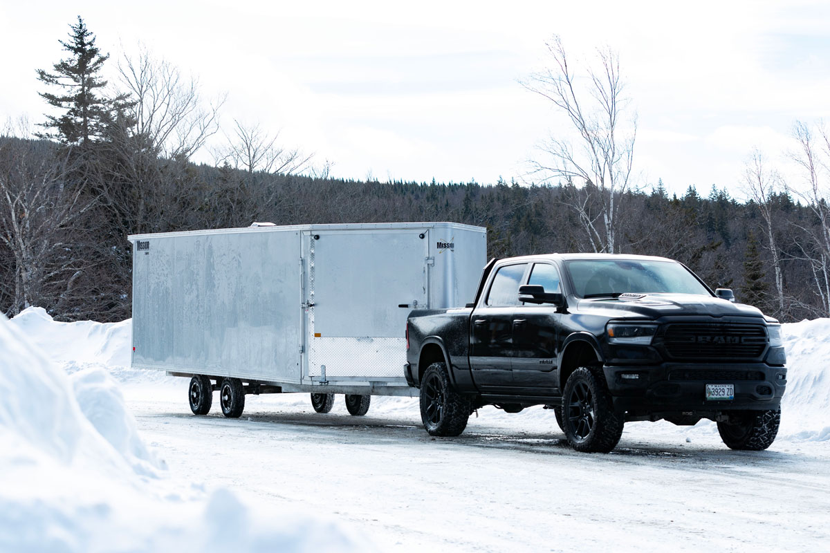 Enclosed Deckover 6.5-Height Snow Trailer Hooked To Black Truck
